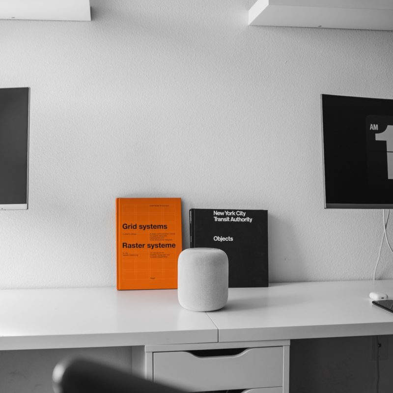 White desk with orange and black books leaning on wall
